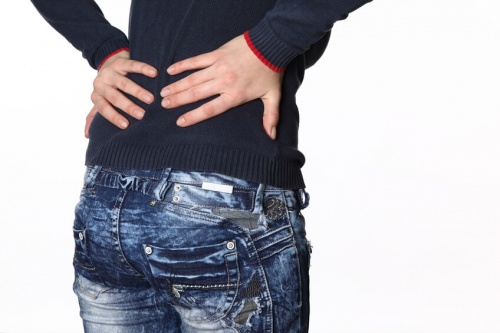 donna con dolori alle ossa e mani sul tratto lombare