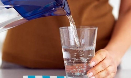 Donna versa acqua in un bicchiere