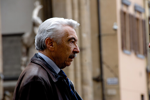 Uomo anziano di profilo con i capelli bianchi e i baffi