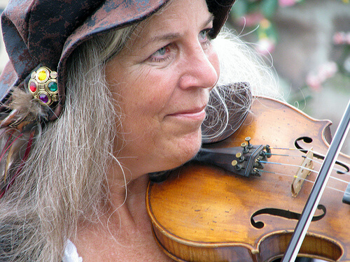 Donna anziana con i capelli bianchi e lunghi e violino