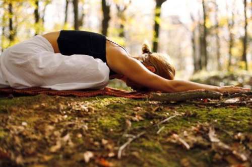 donna che fa yoga nel bosco