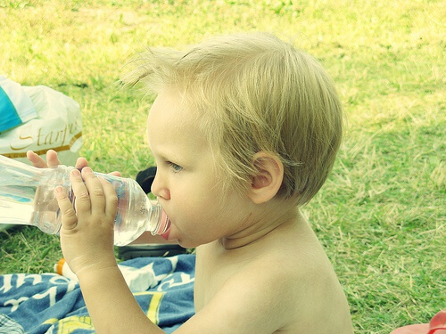 bambino beve acqua da bottiglia