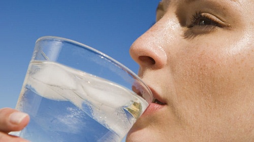 Donna beve un bicchiere di acqua