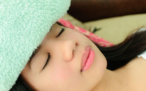 ragazza con impacco per mal di testa