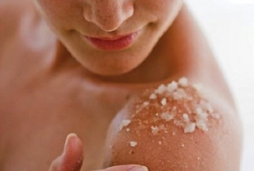 Donna esfolia le spalle con il sale