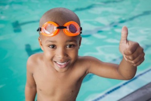 Bambino in piscina con occhialini 