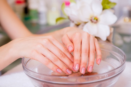 Mani immerse nell'acqua calda