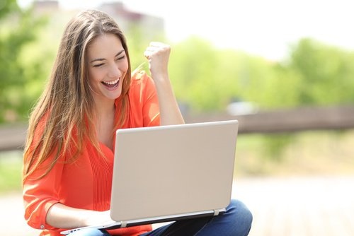 ragazza al computer molto soddisfatta