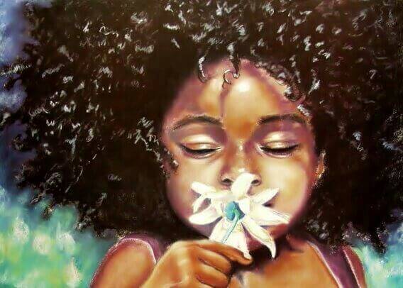 bambina di colore che annusa un fiore