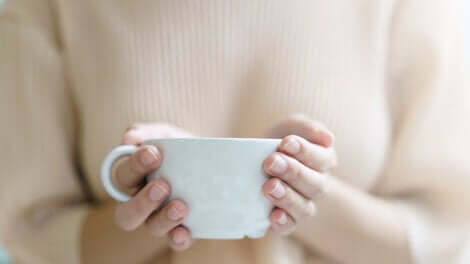 Donna che sostiene una tazza.