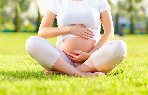Donna incinta seduta al parco