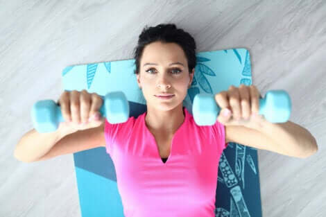 Ragazza che si allena con i manubri.