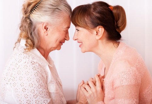 signora anziana che da la mano ad una donna più giovane