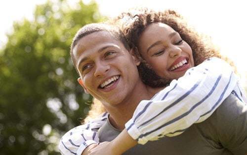 Coppia abbracciata che sorride.