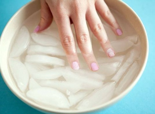 Mano nell'acqua gelata per fare asciugare lo smalto in fretta