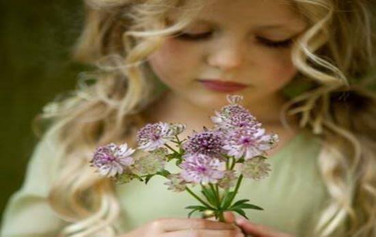 bambina bionda con fiori in mano