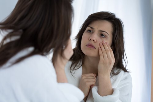 donna con occhiaia si guarda allo specchio problemi estetici