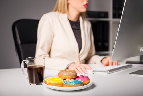 donna che lavora e mangia ha emicrania