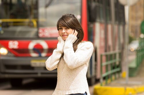ragazza che si tappa le orecchie soffre di emicrania