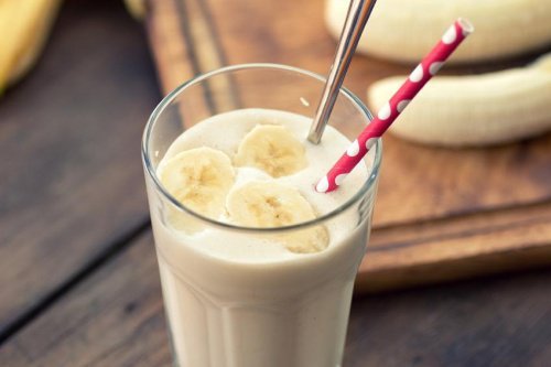 Bicchiere con frullato di banana e cannuccia