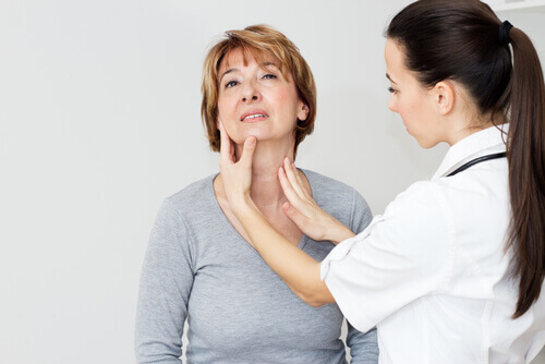 dottoressa tocca la tiroide di una paziente