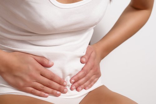 donna con mani su basso ventre trattenere l'urina