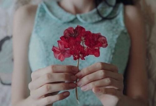 ragazza-con-fiore-in-mano-umile