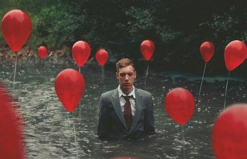 Uomo nel fiume con palloncini
