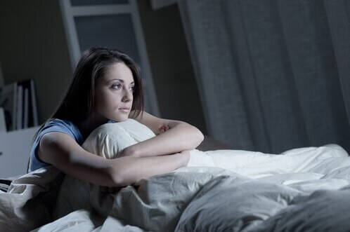 Donna con insonnia seduta nel letto