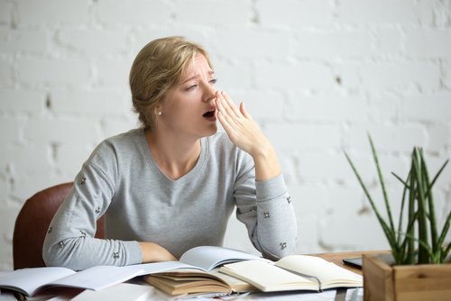 Ragazza sbadiglia mentre studia