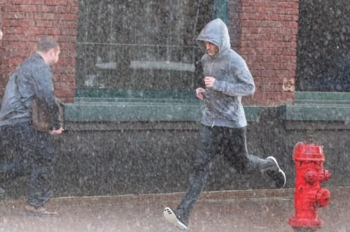 Ragazzo che corre con la pioggia