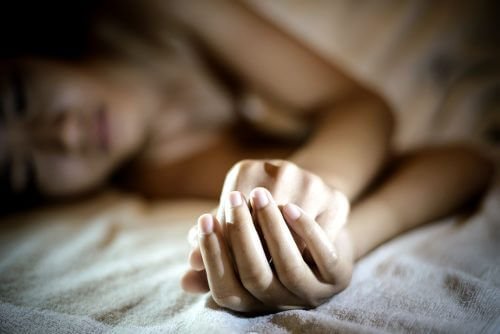 Donna triste stesa sul letto