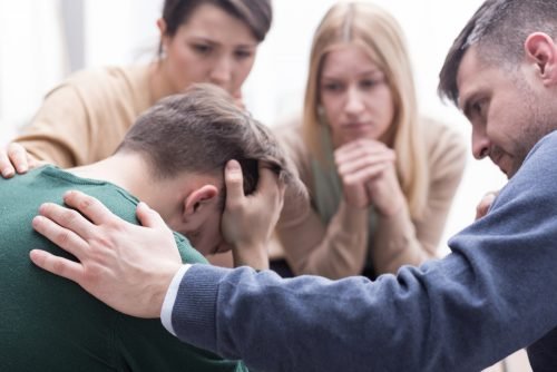 Amici consolano uomo vittima di maltrattamento psicologico
