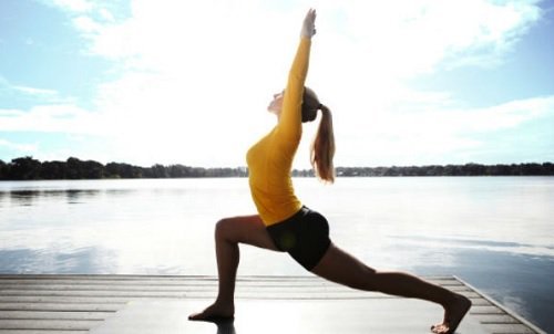 Ragazza esegue posizione yoga del guerriero