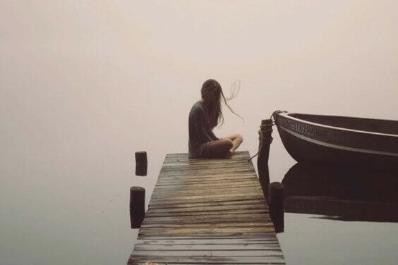 ragazza seduta da sola su un molo