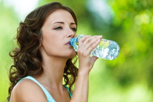 Ragazza che beve da bottiglia di plastica