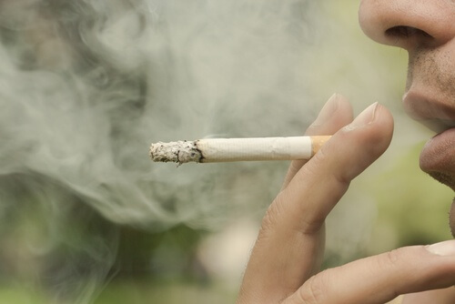 Uomo che butta fuori il fumo della sigaretta