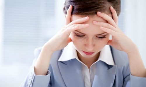 Donna che si regge la testa con le mani