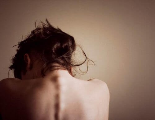 Donna di spalle con la testa abbassata