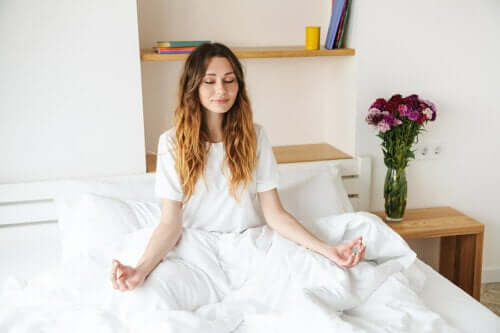 Diventare una persona più tranquilla: ragazza che fa meditazione sul letto.