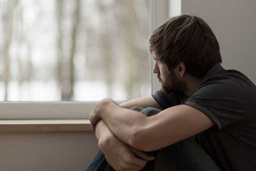 Ragazzo triste guarda fuori dalla finestra