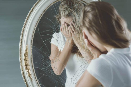 Donna davanti ad uno specchio rotto che rappresenta il mentire a sé stessi