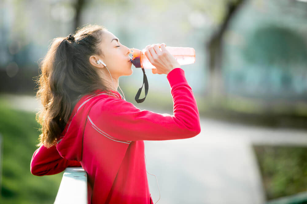 Ragazza che beve una bevanda isotonica