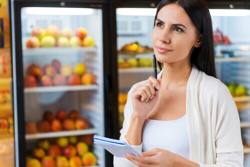 Donna che riguarda lista della spesa prima di comprare