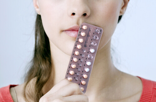 Donna con confezione di pillole come metodo contraccettivo