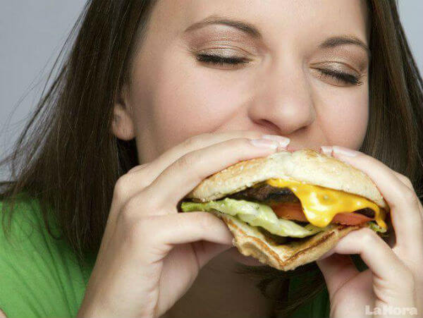 Ragazza mangia un panino di gusto