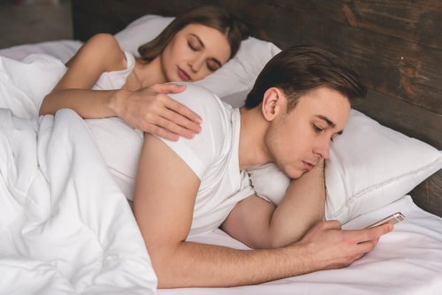 Ragazzo guarda il cellulare a letto