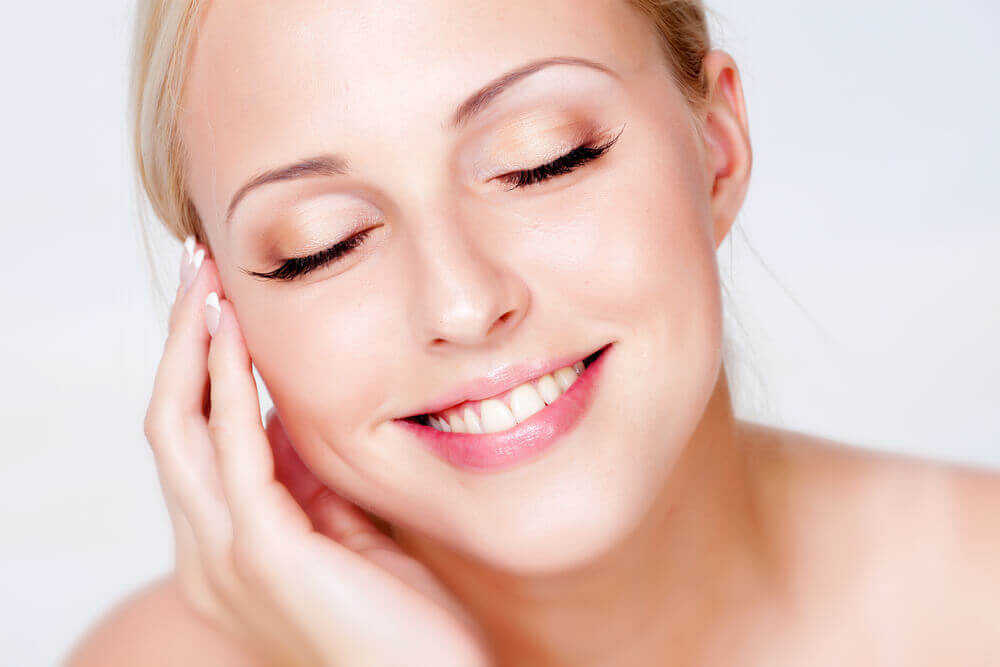 Donna sorridente che si tocca il viso