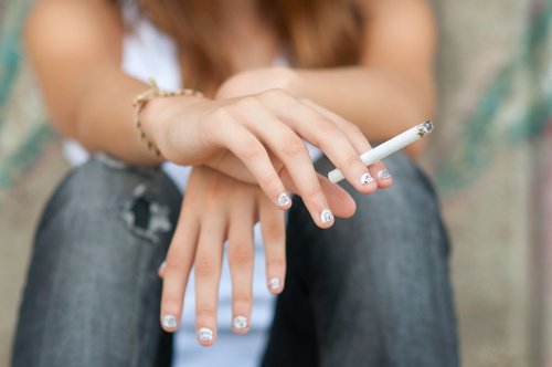 ragazza seduta con sigaretta in mano