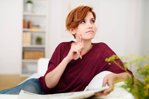 donna seduta con matita e giornale che pensa